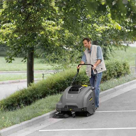 Hombre limpiando la calle con barredora industrial